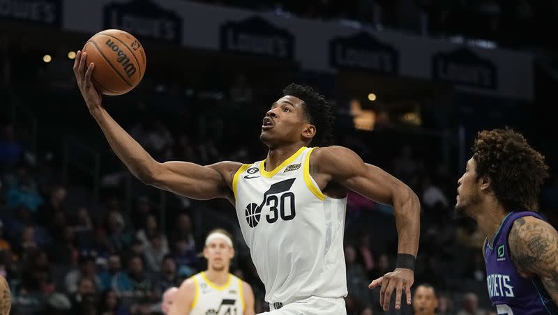 Utah Jazz guard Ochai Agbaji drives to the basket past Charlotte Hornets guard James Bouknight during the first half of an NBA basketball game on Saturday, March 11, 2023, in Charlotte, N.C.