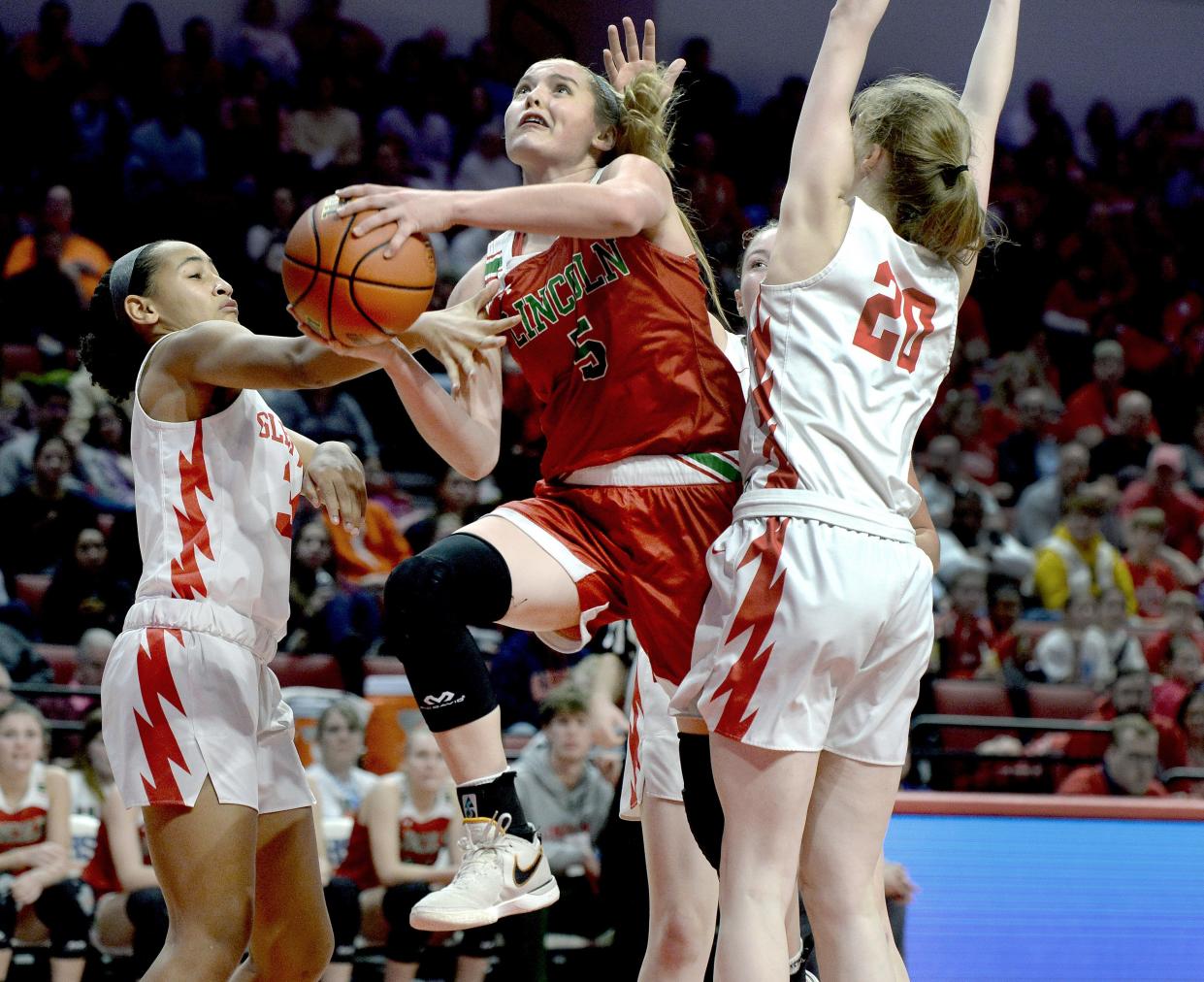 Lincoln's Kloe Froebe drives through Glenwood defenders toward the basket during the Girls Class 3A Basketball State Championship at the CEFCU Arena Saturday, March 2, 2024.