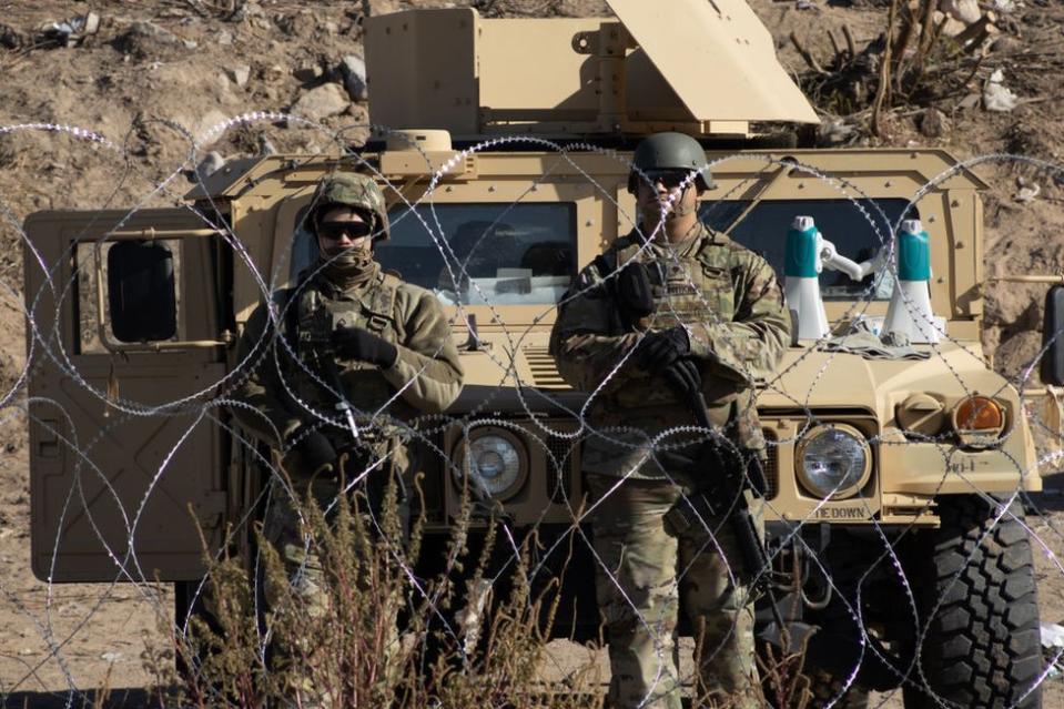 Efectivos de la Guardia Nacional de Texas al otro lado de la alambrada cerca del río Bravo, en El Paso, Texas, EE.UU., vista desde Ciudad Juárez, Chihuahua, México, el 20 de diciembre de 2022.