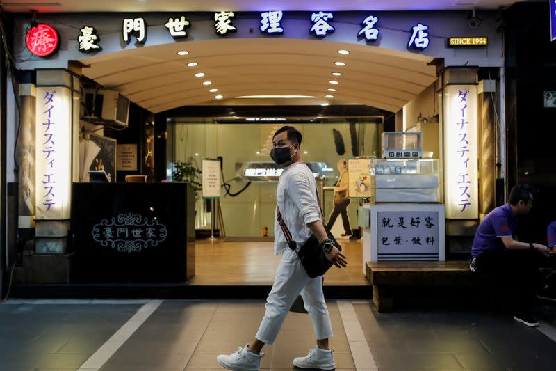 A person wearing a face mask as a preventive measure against the coronavirus disease (COVID-19) walks past Dynasty massage parlour in Taipei
