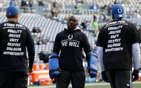 Robert Mathis, centre, a pass rush consultant with his former team, the Indianapolis Colts, stands with players during warmups before an NFL football game against the Seattle Seahawks in Seattle - Credit: AP