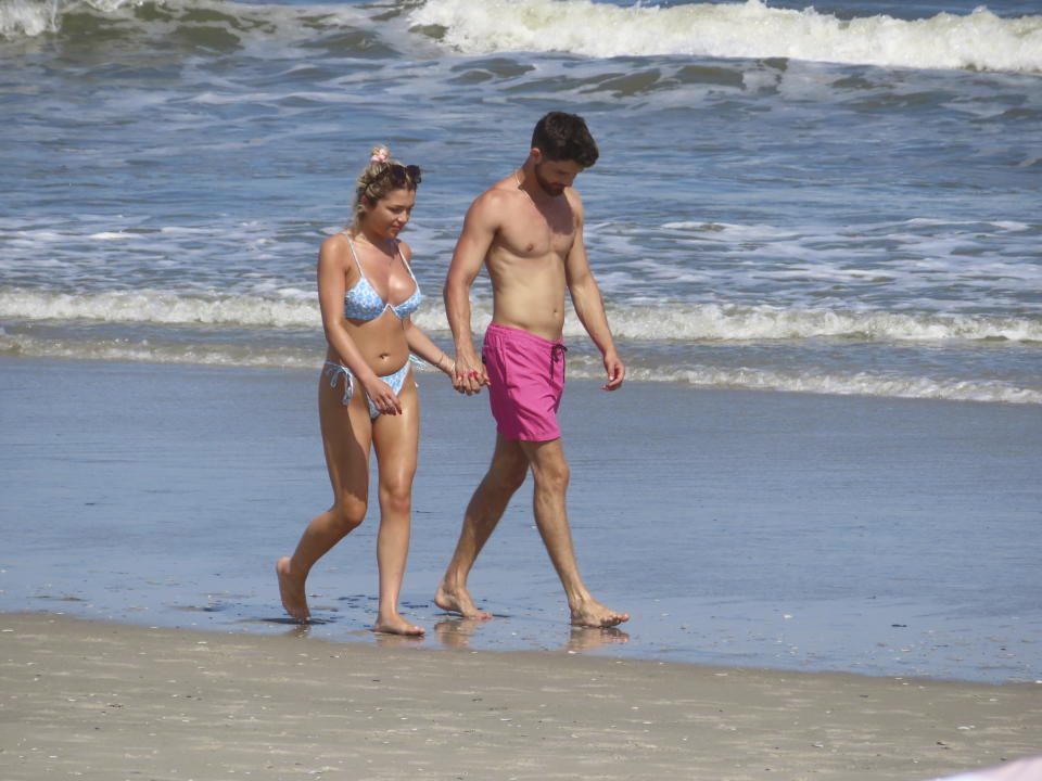 People walk on the beach in Brigantine, N.J. on June 28, 2022. A measure being considered by New Jersey lawmakers that would place a question on the November general election ballot asking whether New Jersey's Constitution should be amended to guarantee citizens the right to a clean environment was advanced by a state Senate committee on March 14, 2024. (AP Photo/Wayne Parry)