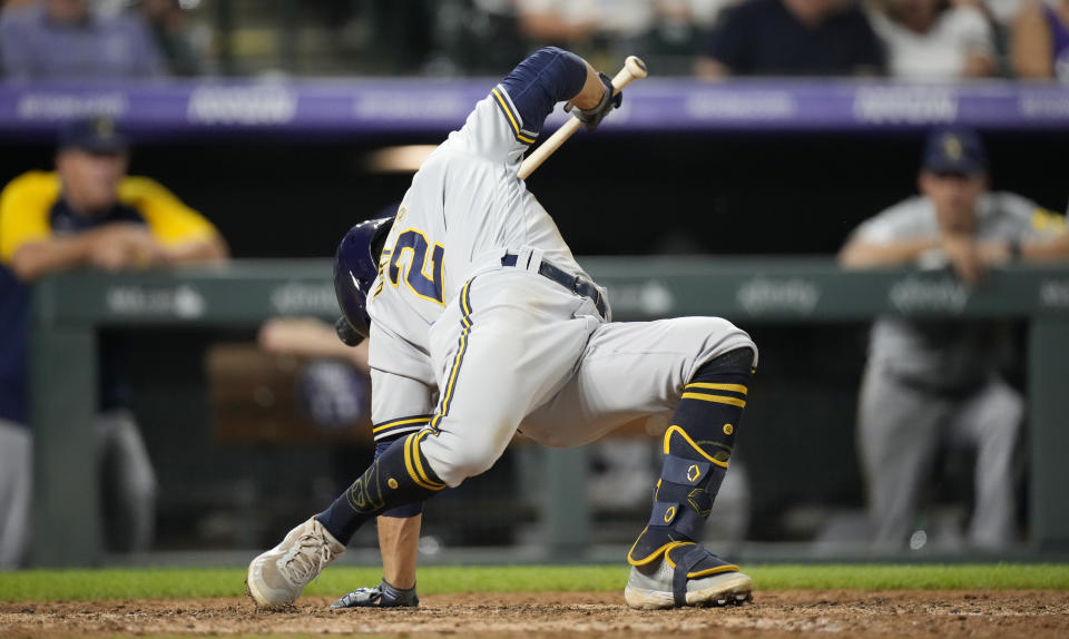 Milwaukee Brewers' Luis Urias avoids a high, inside pitch from Colorado Rockies reliever Yency Almonte during the seventh inning of a baseball game Saturday, June 19, 2021, in Denver. (AP Photo/David Zalubowski)