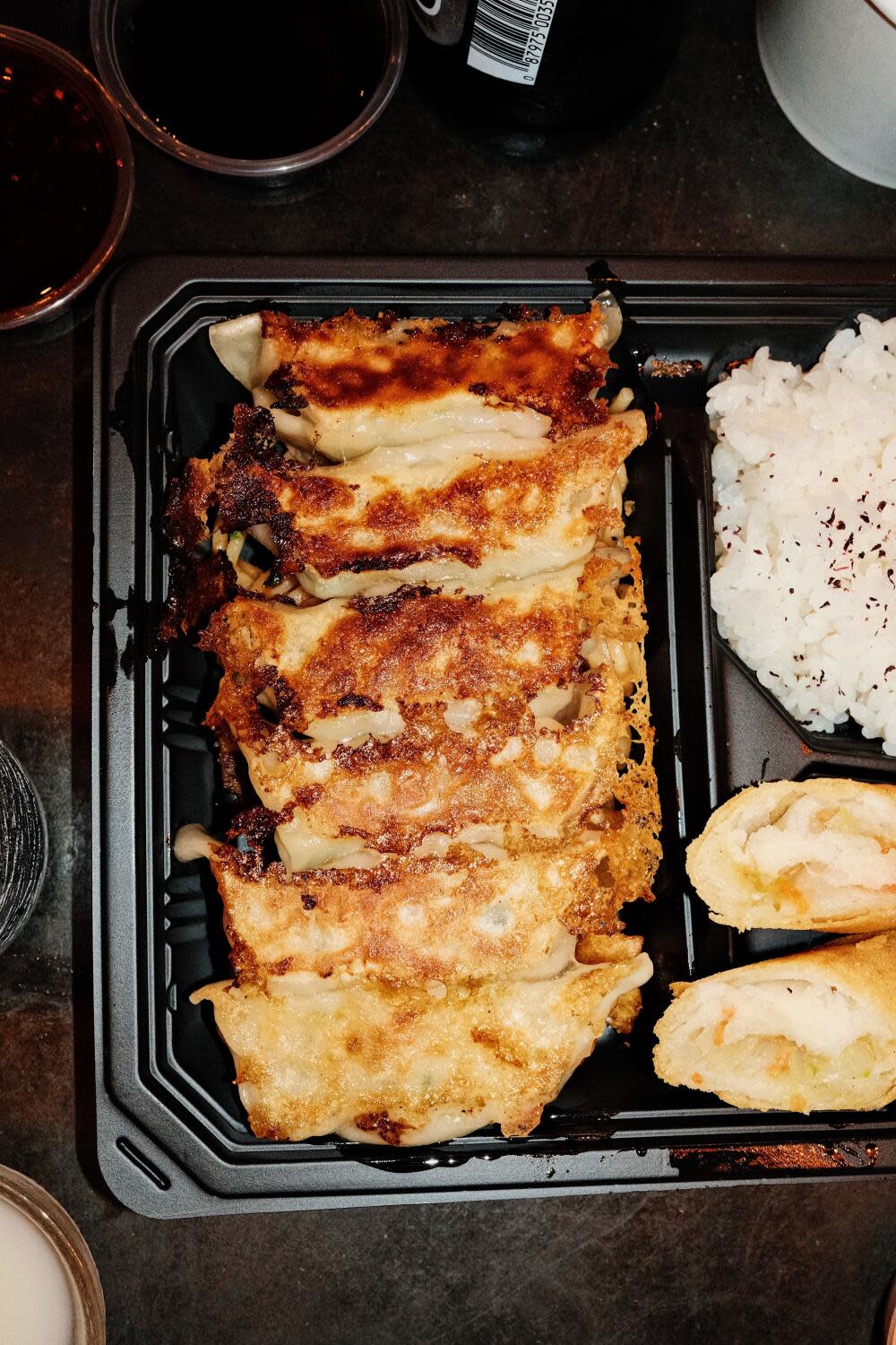 A vertical overhead of a line of six fried gyoza in a bento box at Kaminari Gyoza Bar in Little Tokyo