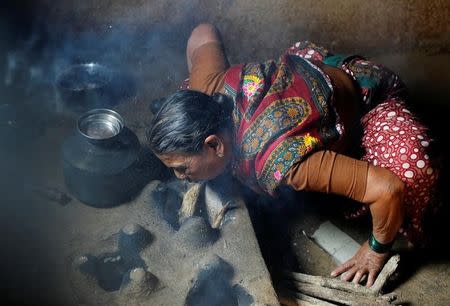 Kamal Keshavtupange, 60, who studies at Aajibaichi Shaala (Grandmothers' School), lights fire as she cooks food on a stove inside her house in Fangane village, India, February 15, 2017. REUTERS/Danish Siddiqui