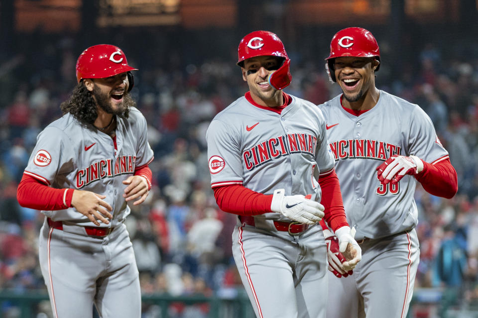 Cincinnati Reds' Spencer Steer, center, celebrates his grand slam with Jonathan India, left, and Will Benson during the tenth inning of a baseball game against the Philadelphia Phillies, Monday, April 1, 2024, in Philadelphia. (AP Photo/Chris Szagola)