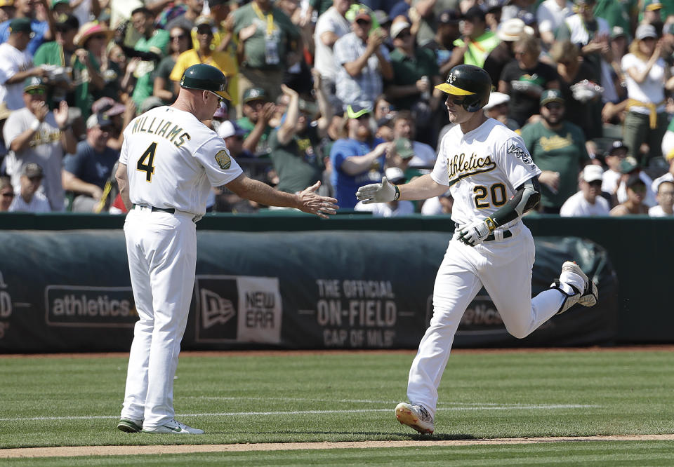 Oakland Athletics’ Mark Canha, right, is congratulated by third base coach Matt Williams after hitting a solo home run against the New York Yankees during the fifth inning of a baseball game in Oakland, Calif., Monday, Sept. 3, 2018. (AP Photo/Jeff Chiu)