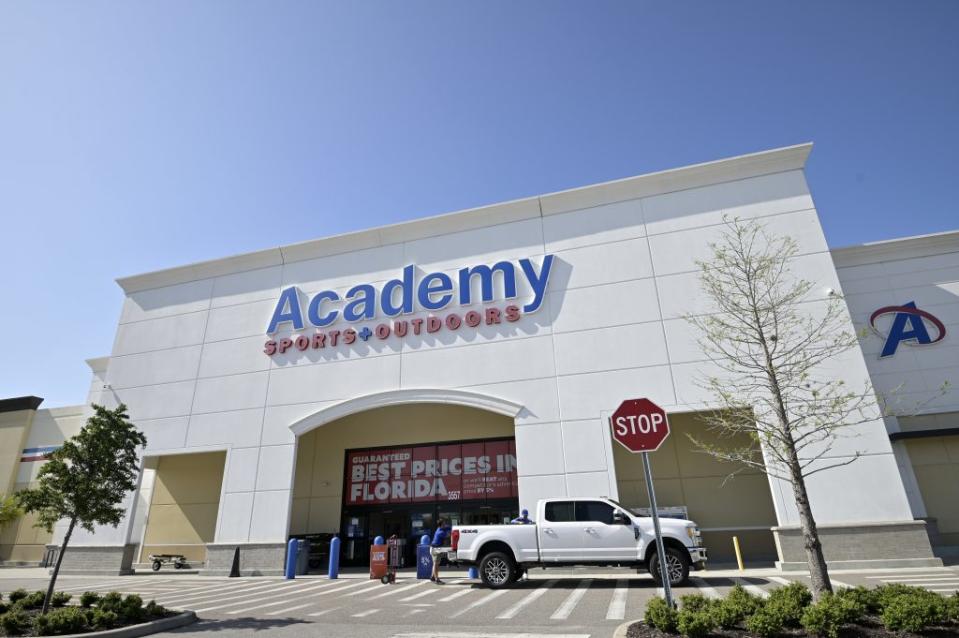 An employee helps load an item into a truck outside an Academy Sports + Outdoors store in Orlando, Fla. - Credit: Phelan M. Ebenhack/AP