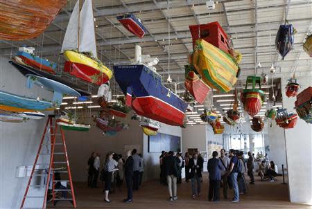 Media members stand near a work titled "For Those in Peril on the Sea" by artist Hew Locke during a tour of the Perez Art Museum Miami (PAMM) in Miami, Florida December 3, 2013. REUTERS/Joe Skipper