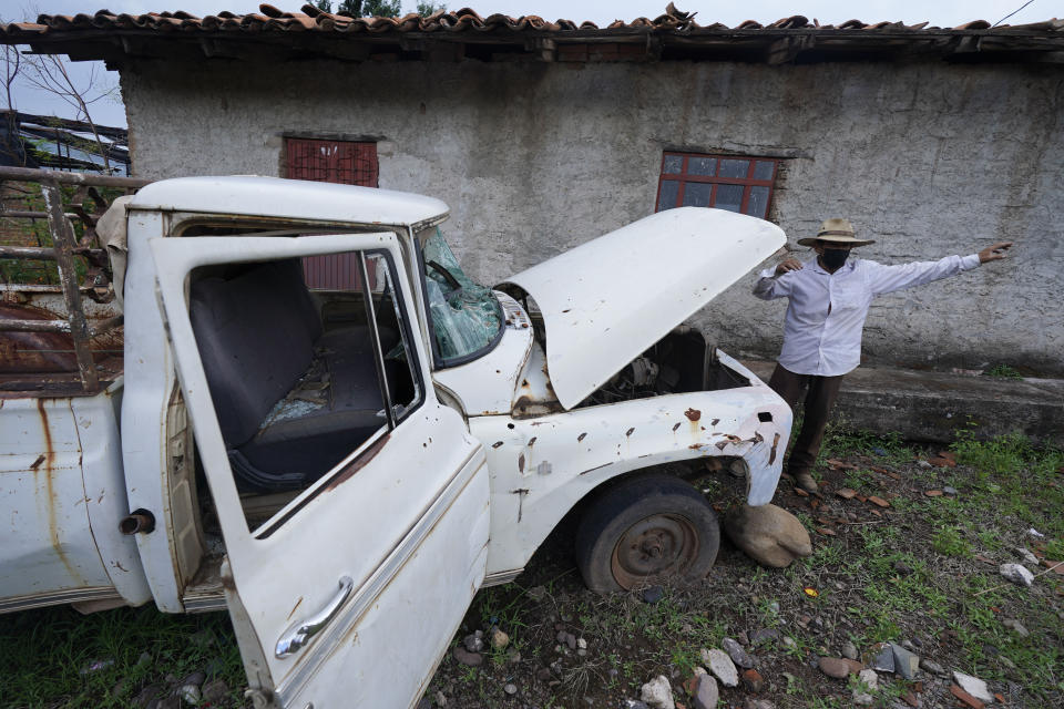 A villager talks about the damage to his truck that he claims was caused by gunshots fired by soldiers at an army barracks that residents have barricaded, in Aguililla, in the Michoacan state of Mexico, Friday, Oct. 29, 2021. The army has largely stopped fighting drug cartels here, instead ordering soldiers to guard the dividing lines between gang territories so they won’t invade each other’s turf _ and turn a blind eye to the cartels’ illegal activities just a few hundred yards away. (AP Photo/Eduardo Verdugo)