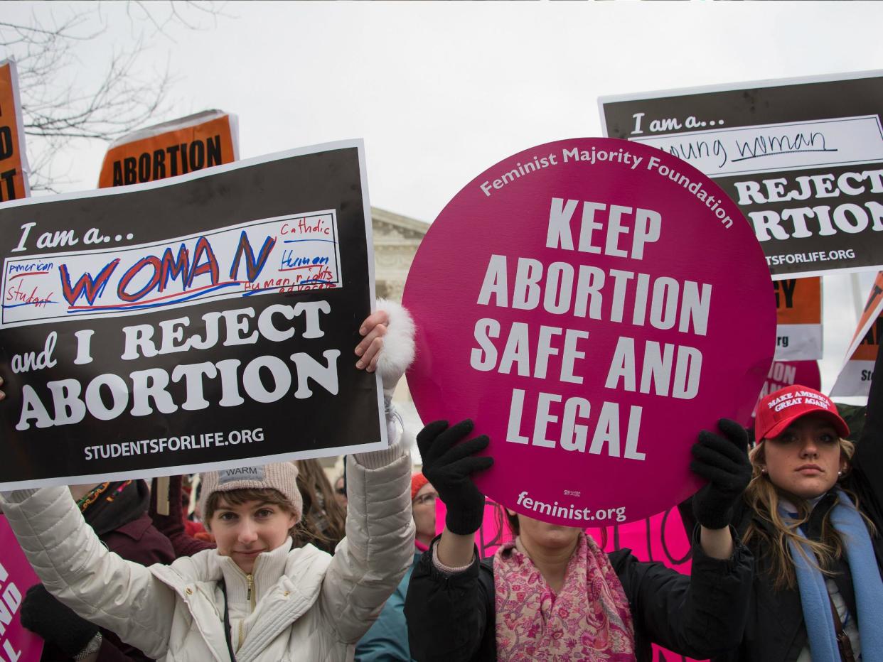 A pro-choice activist (C) demonstrates in the middle of pro-life activists as they demonstrate in front of the US Supreme Court during the March For Life in Washington DC, 27 January 2017: JIM WATSON/AFP/Getty Images