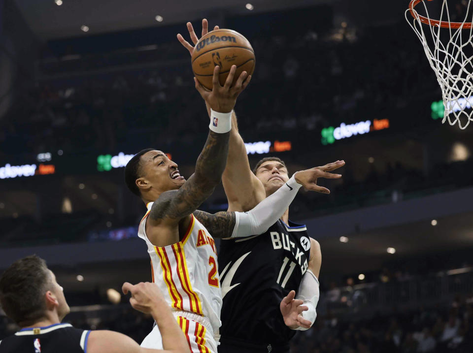 Atlanta Hawks forward John Collins (20) drives to the basket against Milwaukee Bucks' Brook Lopez during the first half of an NBA basketball game, Saturday, Oct. 29, 2022, in Milwaukee. (AP Photo/Jeffrey Phelps)