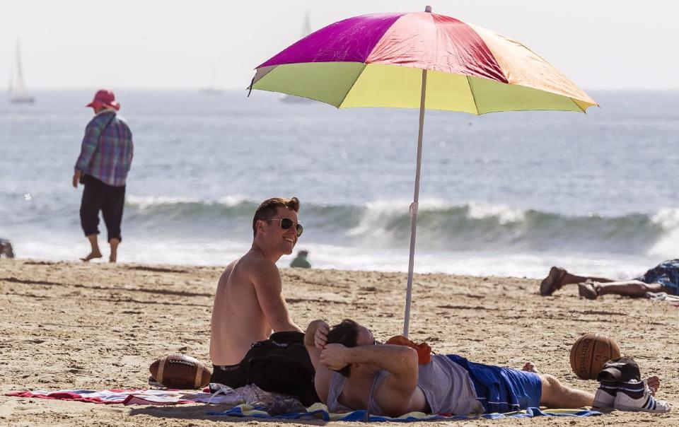 Beach goers enjoy the warm weather in the Venice Beach area of Los Angeles, Friday, Feb. 14, 2014. With much of the Northeast gripped by snow and ice storms, the Southwest is riding a heat wave that is setting record high temperatures and sent people to beaches and golf courses in droves Friday. (AP Photo/Damian Dovarganes)