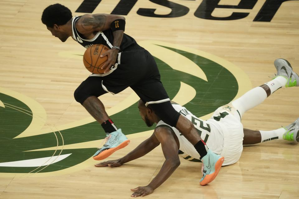Brooklyn Nets' Kyrie Irving steals the ball from Milwaukee Bucks' Khris Middleton during the first half of Game 4 of the NBA Eastern Conference basketball semifinals game Sunday, June 13, 2021, in Milwaukee. (AP Photo/Morry Gash)