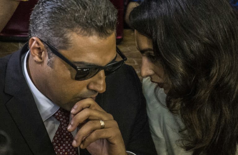 Al-Jazeera journalist, Canadian Mohamed Fahmy (L), talks to human rights lawyer Amal Clooney, during the trial in Cairo on August 29, 2015