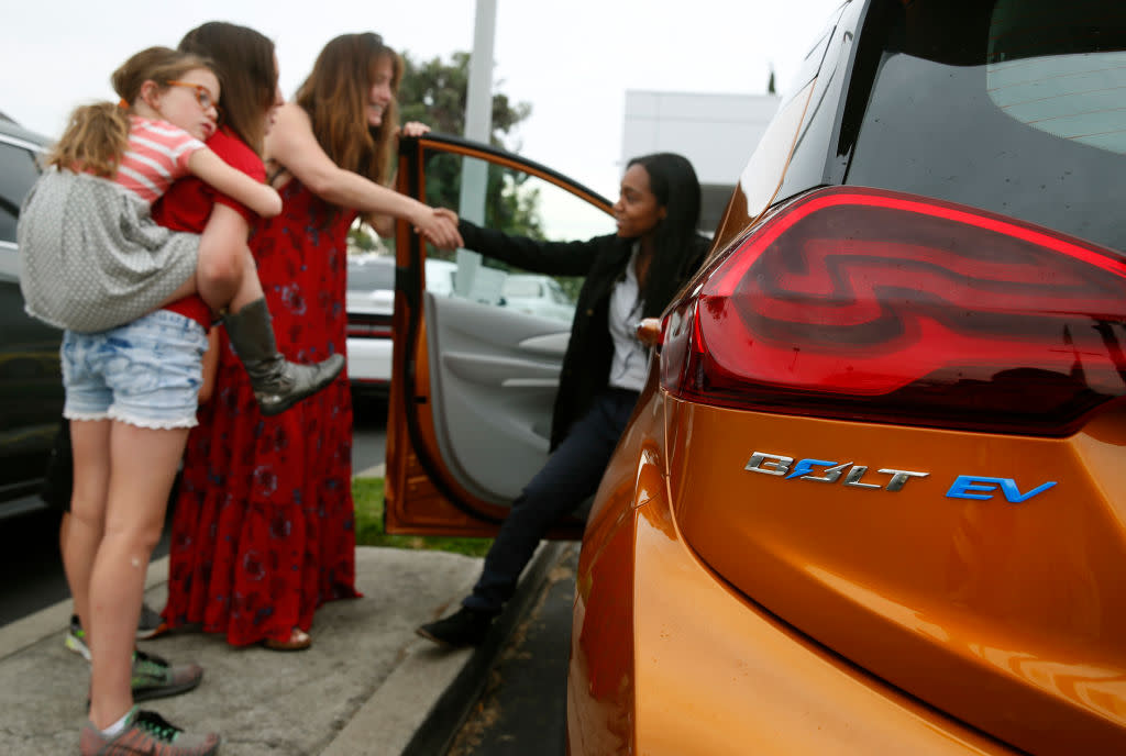  Woman test-drives Chevy electric vehicle. 