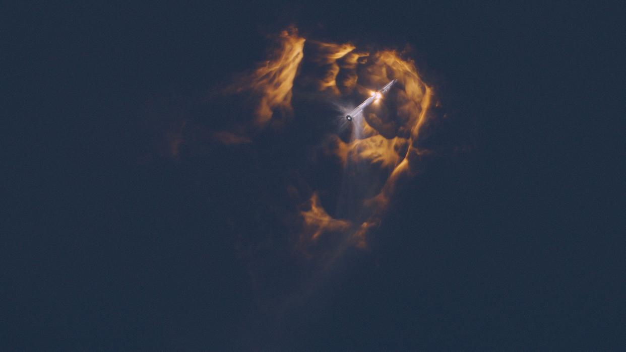  A giant rocket separating during stage separation, with fiery plumes in all directions. 