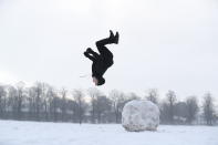 Jack Austin does a backflip off a snowball on Knutsford Heath in Cheshire. (PA)