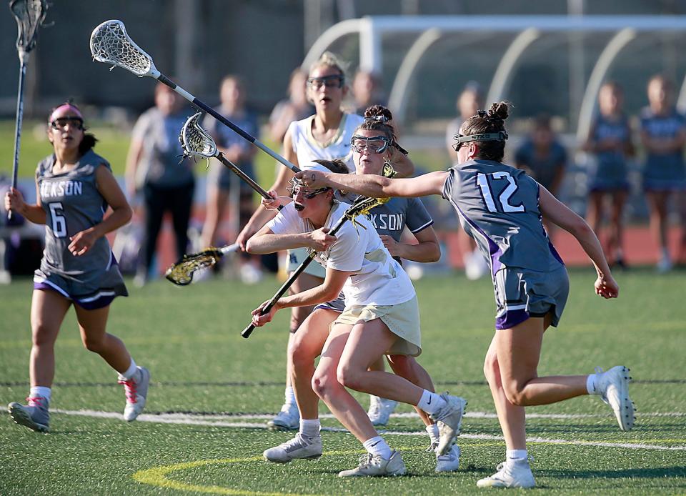 New Albany's Ellie McClelland is pressured by Jackson's Cam Meek and Allie Hartnett (12) as she attempts to get a shot off during their lacrosse match Tuesday, May 31, 2022 at Ashland University. TOM E. PUSKAR/TIMES-GAZETTE.COM