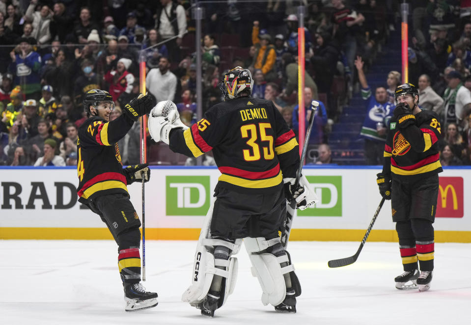 Vancouver Canucks' Pius Suter, left, and goalie Thatcher Demko (35) celebrate as Ian Cole, right, watches after Vancouver defeated the Chicago Blackhawks during an NHL hockey game, in Vancouver, British Columbia, on Monday, Jan. 22, 2024. (Darryl Dyck/The Canadian Press via AP)