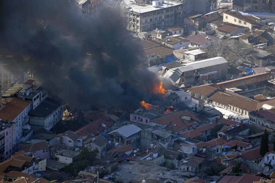 Smoke rises from a building in Antakya, southern Turkey, Wednesday, Feb. 8, 2023. With the hope of finding survivors fading, stretched rescue teams in Turkey and Syria searched Wednesday for signs of life in the rubble of thousands of buildings toppled by a catastrophic earthquake. (AP Photo/Khalil Hamra)