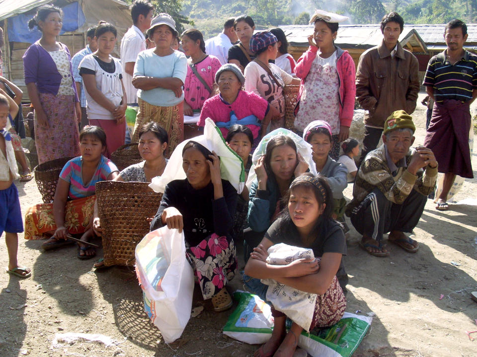 FILE - In this Jan. 4, 2013, file photo, Kachin refugees wait for rations at the Je Yang IDP camp, the biggest and closest camp to Laiza, Laiza, northeastern Myanmar. A human rights group says the governments in Myanmar and China are failing to stop the brutal trafficking of young women from the conflict-ridden Kachin region for sexual slavery. (AP Photo/Yadana Htun, File)