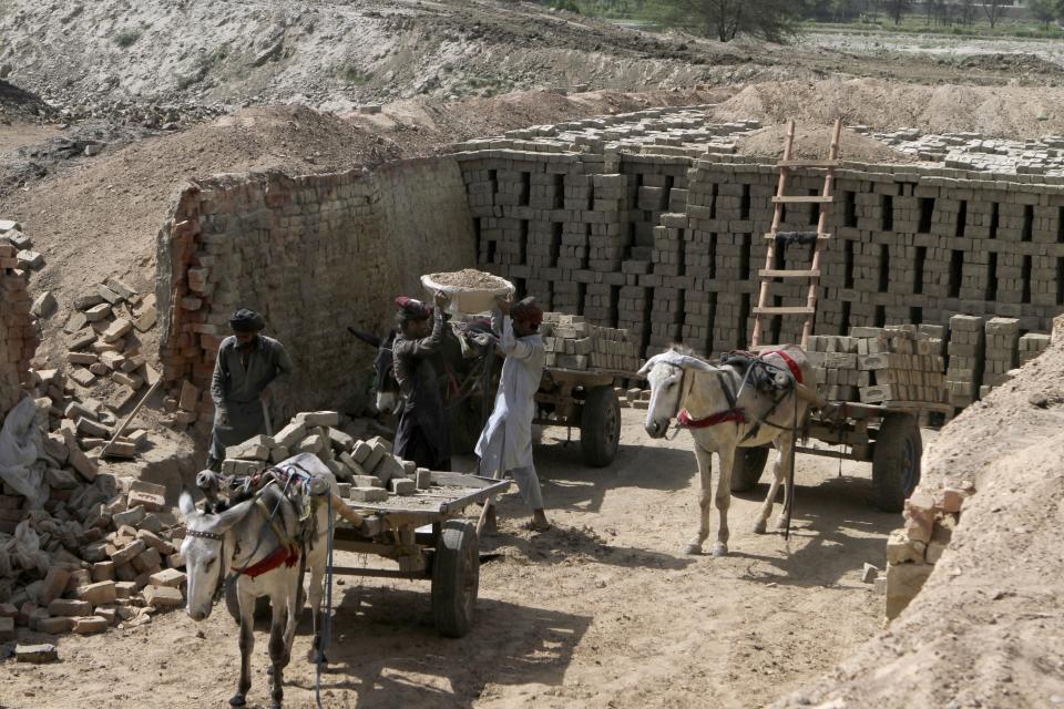 Laborers work at a brick kiln in Rajanpur, a district of Pakistan's Punjab province, Sunday, May 21, 2023. Punjab is Pakistan’s biggest agricultural producer and its most populated province. (AP Photo/Asim Tanveer)