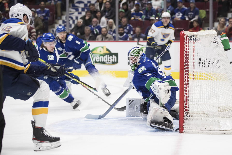 St. Louis Blues' Zach Sanford, left, scores against Vancouver Canucks goalie Thatcher Demko during the first period of an NHL hockey game in Vancouver, British Columbia on Monday Jan. 27, 2020. (Darryl Dyck/The Canadian Press via AP)