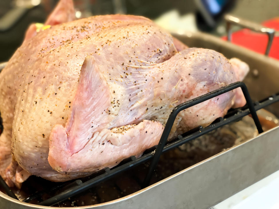 raw turkey on a roasting rack