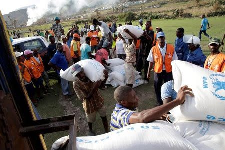 Haitians load supplies delivered by a Marines helicopter after Hurricane Matthew in Les Anglais, Haiti, October 11, 2016. REUTERS/Andres Martinez Casares