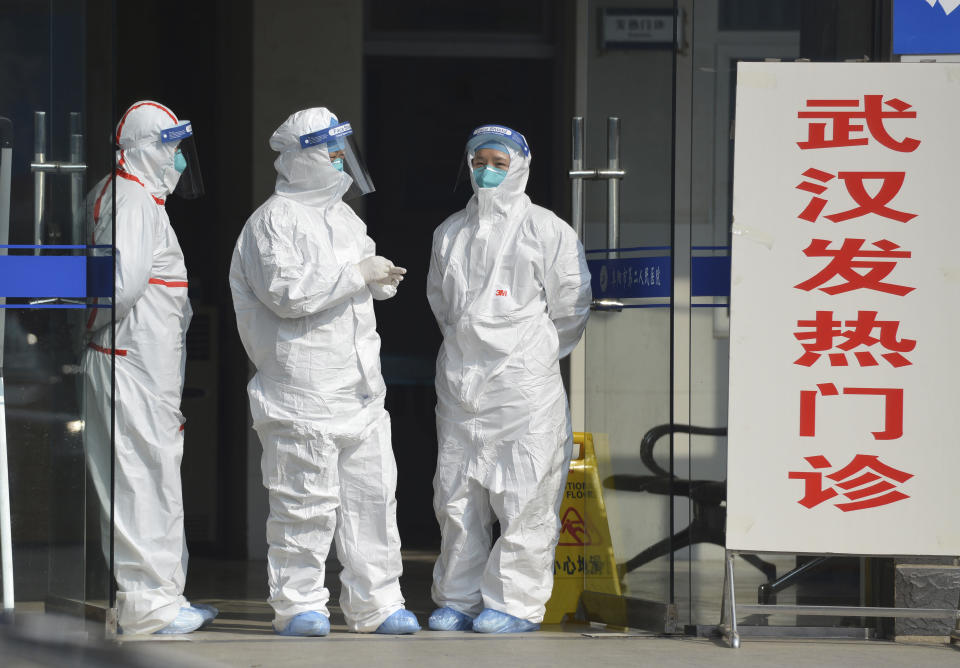 FILE - In this Jan. 28, 2020 file photo, medical staff in protective outfits wait at the entrance of a clinic for fever patients and patients from Wuhan in Fuyang in central China's Anhui Province. As China institutes the largest quarantine in human history, locking down more than 50 million people in the center of the country, those who have recently been to Wuhan are being tracked, monitored, turned away from hotels and shoved into isolation at their homes and in makeshift quarantine facilities. (Chinatopix via AP. File)