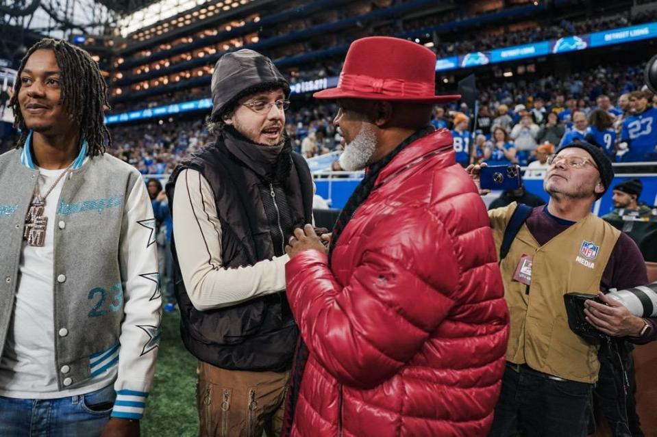 Rapper Jack Harlow greets Detroit singer-songwriter Cadillac Dale (right) at Ford Field in Detroit on Nov. 23, 2023. Detroit artist Skilla Baby is pictured at left.