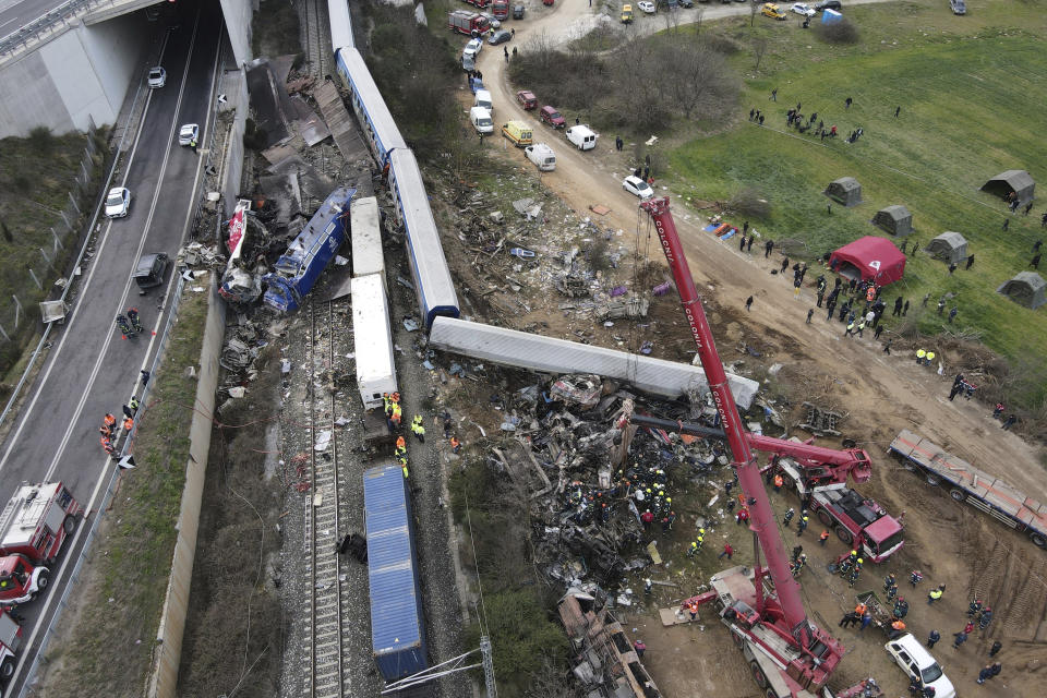 Debris of trains lie on the rail lines after a collision in Tempe, about 376 kilometres (235 miles) north of Athens, near Larissa city, Greece, Wednesday, March 1, 2023. A passenger train carrying hundreds of people, including many university students returning home from holiday, collided at high speed before midnight Tuesday with an oncoming freight train. (AP Photo/Giannis Papanikos)