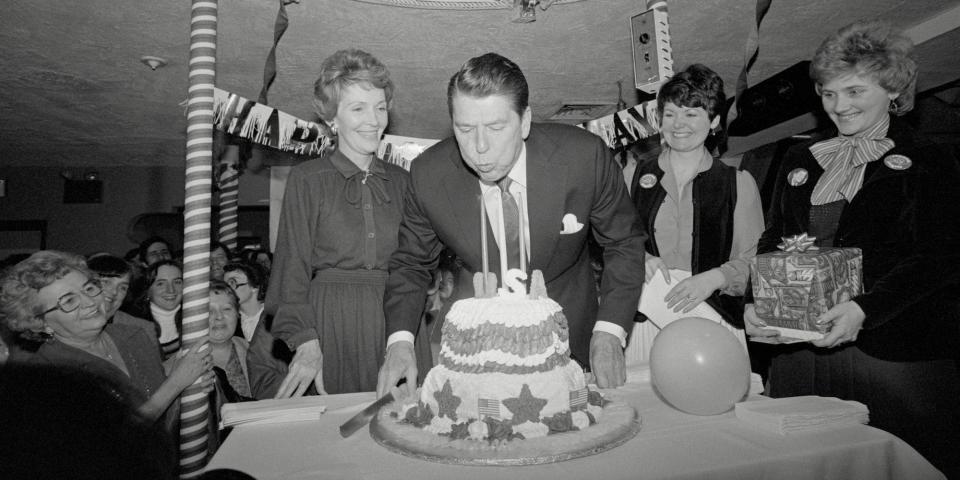 GOP presidential candidate Ronald Reagan blows out birthday candles on February 6, 1980, while his wife, Nancy looks on.
