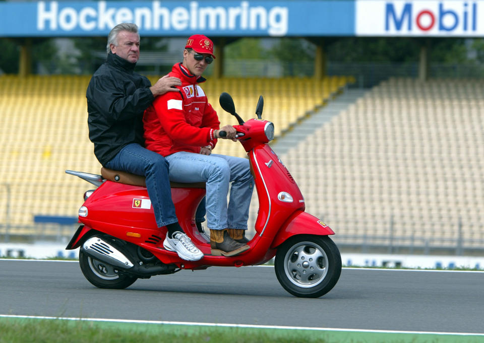 La leyenda de la Fórmula 1 Michael Schumacher usa un scooter y lleva como pasajero a su manager Willi Weber en Hockenheim, el 25 de julio de 2002. (Foto: REUTERS/Kai Pfaffenbach KP/CRB)
