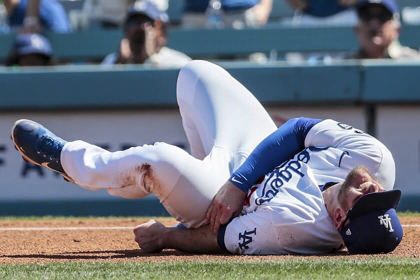 Los Angeles, CA, Sunday, October 3, 2021 -Los Angeles Dodgers first baseman Max Muncy (13) writhes in pain after colliding with Milwaukee Brewers second baseman Jace Peterson (14) in the third inning at Dodger Stadium. (Robert Gauthier/Los Angeles Times)