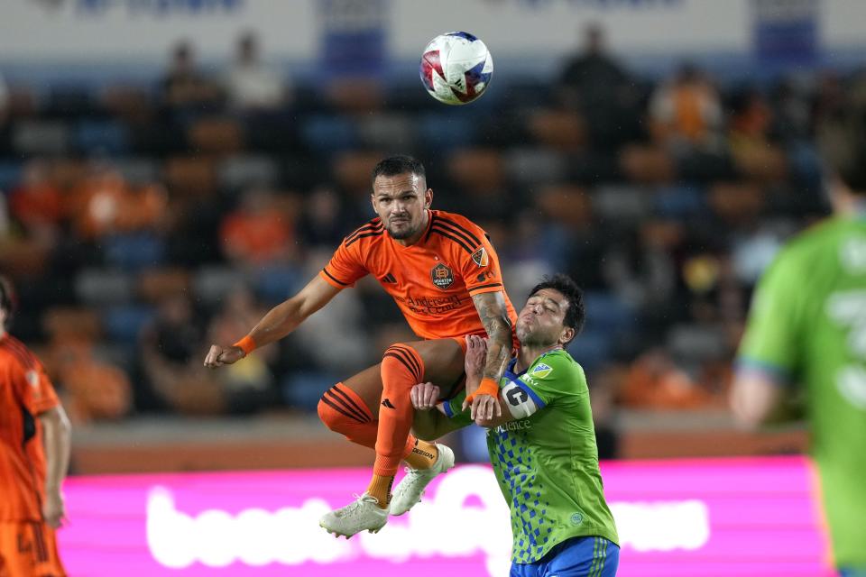 Houston Dynamo's Artur, left, goes up for a header as Seattle Sounders' Nicolás Lodeiro collides with him during the first half of an MLS soccer match Saturday, May 13, 2023, in Houston. (AP Photo/David J. Phillip)