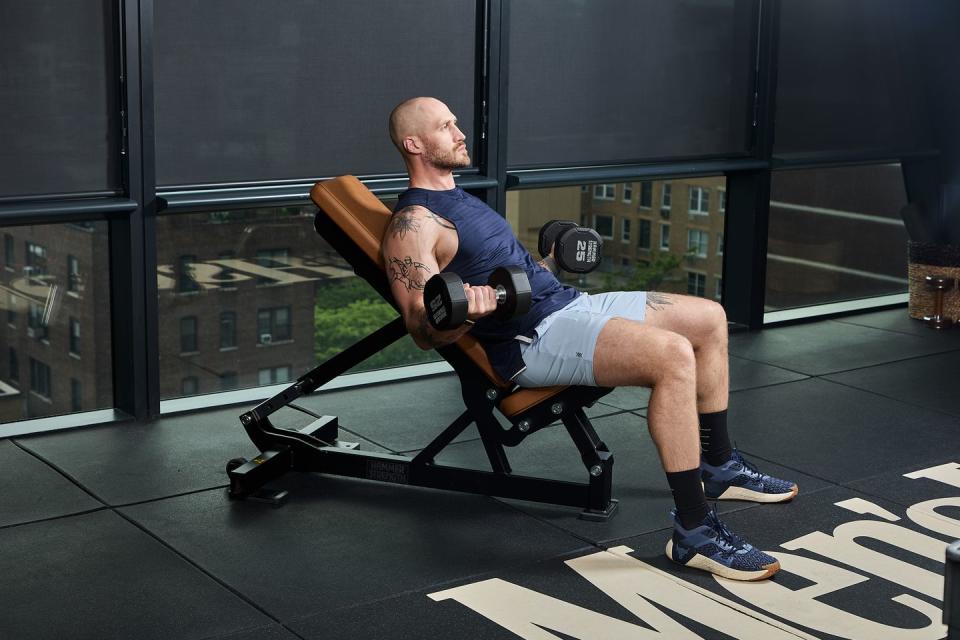 a man sitting on a bench with a gun