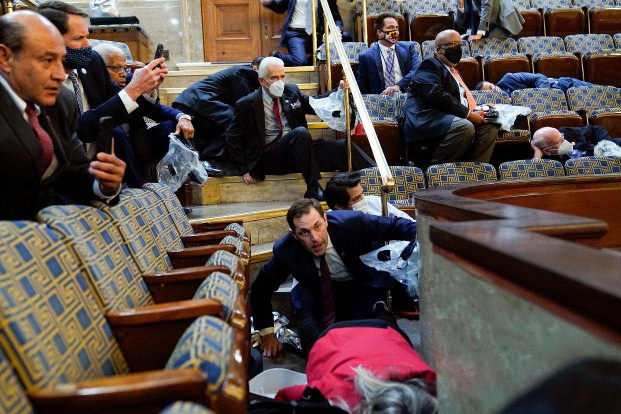 Members of Congress shelter in the House gallery as people try to break into the House Chamber at the U.S. Capitol on Jan. 6, 2021.