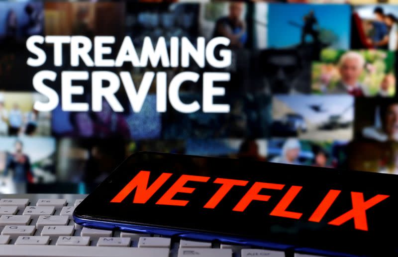 FILE PHOTO: A smartphone with the Netflix logo is seen on a keyboard in front of displayed "Streaming service" words in this illustration