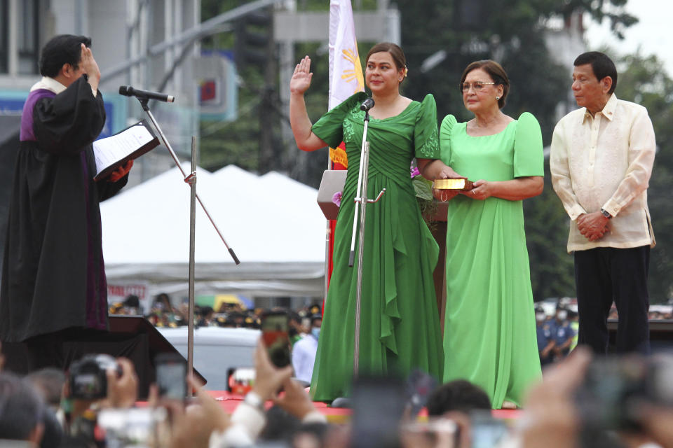 Sara Duterte, second from left, the daughter of outgoing populist president of the Philippines, takes her oath as vice president during rites in her hometown in Davao city, southern Philippines on Sunday June 19, 2022. Duterte clinched a landslide electoral victory despite her father's human rights record that saw thousands of drug suspects gunned down. Also in photo are, from left, Supreme Court Justice Ramon Paul Hernando, her mother Elizabeth Zimmerman and Philippine President Rodrigo Duterte. (AP Photo/Manman Dejeto)