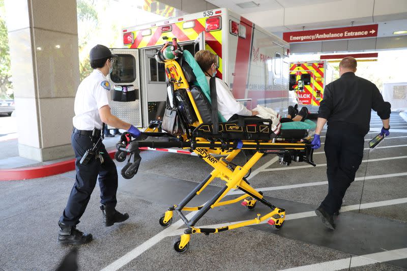 An ambulance crew rushes a coronavirus disease (COVID-19) patient into the emergency department at Providence Mission Hospital in Mission Viejo