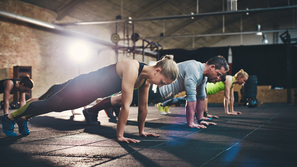  Row of people holding the straight-arm plank position 