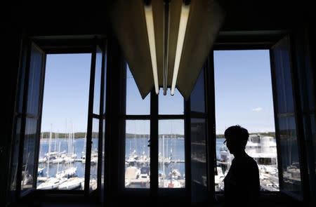 An employee of clothing retailer Arena Modna Kuca looks out of a window at the company's factory in the Adriatic town of Pula July 1, 2014. REUTERS/Antonio Bronic