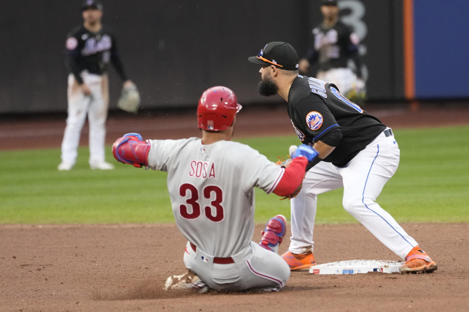 Philadelphia Phillies' Edmundo Sosa (33) slides safely into second past New York Mets second baseman Luis Guillorme after hitting an hits an RBI single during the eighth inning of the first game of a baseball doubleheader, Saturday, Sept. 30, 2023, in New York. (AP Photo/Mary Altaffer)