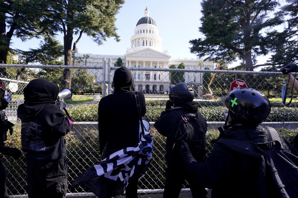 Demonstrators stop at a temporary 6-foot high chain link fence surrounding the state Capitol in Sacramento, Calif., Wednesday, Jan. 20, 2021. Several dozen protesters marched through the downtown area to the Capitol where they were stopped at a temporary fence installed to stop violence on the Inauguration Day of President Joe Biden and Vice President Kamala Harris. (AP Photo/Rich Pedroncelli)