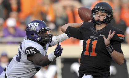 FILE - In this Oct. 27, 2012, file photo, TCU defensive end Devonte Fields, left, pressures Oklahoma State quarterback Wes Lunt, right, during an NCAA college football game in Stillwater, Okla. Field as selected as the AP&#39;s Big 12 defensive player of the year, Wednesday, Dec. 5, 2012. (AP Photo/Brody Schmidt, File)