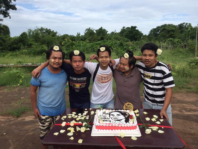 Supporters of Myanmar's detained leader Aung Sang Suu Kyi pose next to her birthday cake in Myanmar