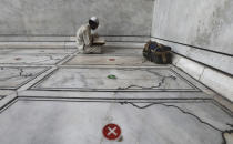 An Indian Muslim offers prayers on the eve of Eid al-Adha with social distancing marking on the floor at Jama Masjid in New Delhi, India, Friday, July 31, 2020. Eid al-Adha, or the Feast of the Sacrifice, is marked by sacrificing animals to commemorate the prophet Ibrahim's faith in being willing to sacrifice his son. (AP Photo/Manish Swarup)