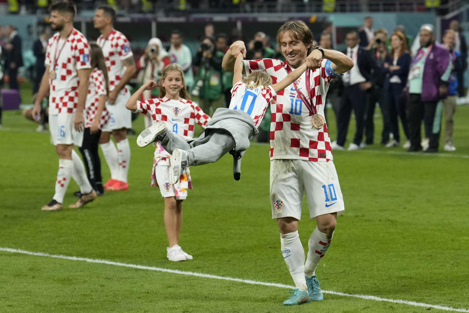 Luka Modric juega con su hija tras ganar la medalla de bronce del Mundial tras la victoria 2-1 de Croacia ante Marruecos en el partido por el tercer lugar, el sábado 17 de diciembre de 2022, en el estadio Jalifa Internacional en Qatar. (AP Foto/Francisco Seco)